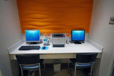 a desk with two monitors and a computer on it at SpringHill Suites by Marriott Madera in Madera