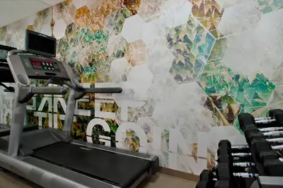 a room with a gym with a wall mural at SpringHill Suites by Marriott Madera in Madera