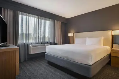 a hotel room with a large bed and a window at Courtyard by Marriott Sacramento Midtown in Sacramento