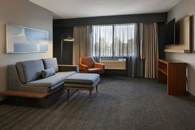 a hotel room with a couch and a chair at Courtyard by Marriott Sacramento Midtown in Sacramento