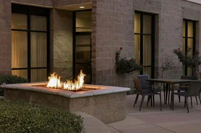 a fire pit outside of a building with a table and chairs at Courtyard by Marriott Sacramento Midtown in Sacramento