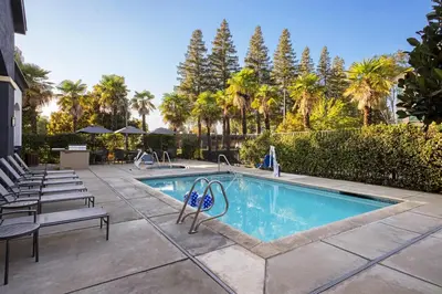 a swimming pool with lounge chairs and trees at Fairfield Inn Sacramento Cal Expo in Sacramento