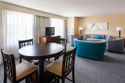 a living room with a couch and a table in a hotel room at Courtyard by Marriott Sacramento Cal Expo in Sacramento