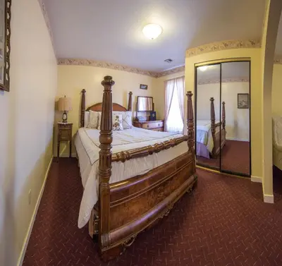 a bedroom with a large bed and a mirror at Historic Cary House Hotel in Placerville