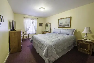 a hotel room with a bed and a television at Historic Cary House Hotel in Placerville