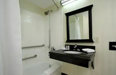 a bathroom with a sink and a tub and a mirror at Fairfield Inn & Suites Fresno Clovis in Clovis
