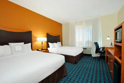 a hotel room with two beds and a television at Fairfield Inn & Suites Fresno Clovis in Clovis