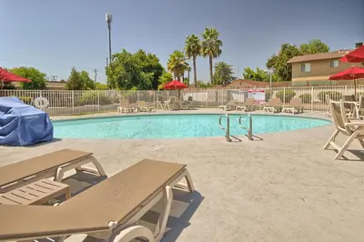 a swimming pool with chairs and a picnic table at Motel 6-Fresno, CA - Blackstone North in Fresno