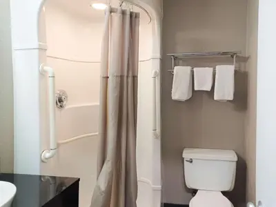 a bathroom with a toilet and a shower with towels at Motel 6-Fresno, CA - Blackstone North in Fresno
