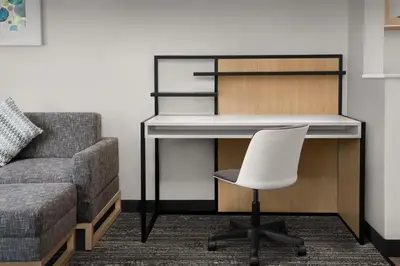 a desk and a chair in a room with a couch at TownePlace Suites Sacramento Cal Expo in Sacramento