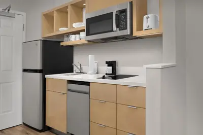 a kitchen with a black refrigerator and a microwave at TownePlace Suites Sacramento Cal Expo in Sacramento