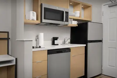 a kitchen with a sink and a tv on a shelf at TownePlace Suites Sacramento Cal Expo in Sacramento