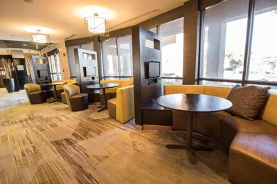 a lobby with a couch and tables and windows at Courtyard by Marriott Merced in Merced