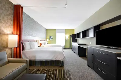 a hotel room with a bed and a flat screen tv at Home2 Suites By Hilton Hanford Lemoore in Hanford