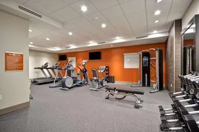 a gym with several treadmills and cardio machines at Home2 Suites By Hilton Hanford Lemoore in Hanford