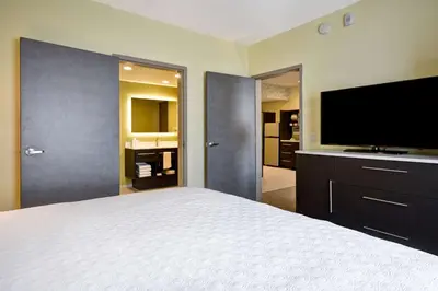 a bedroom with a large bed and a flat screen tv at Home2 Suites By Hilton Hanford Lemoore in Hanford