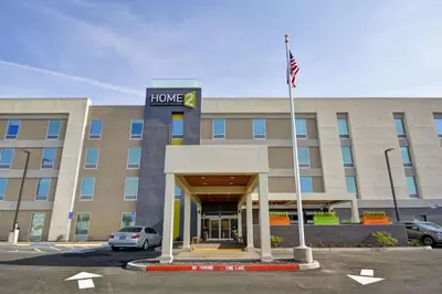 a hotel building with a flag in front of it at Home2 Suites By Hilton Hanford Lemoore in Hanford