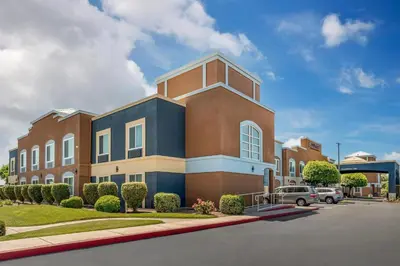 a large brick building with a car parked in a parking lot at Country Inn & Suites by Radisson, Modesto-Salida in Modesto