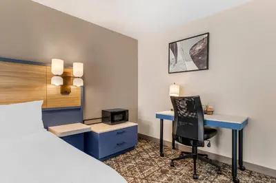 a hotel room with a bed and a desk and a chair at Country Inn & Suites by Radisson, Modesto-Salida in Modesto