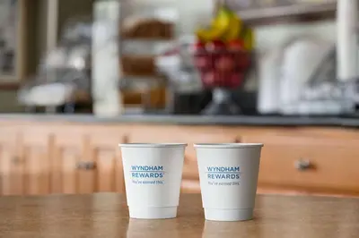 two coffee cups sitting on top of a table at Super 8 by Wyndham Lindsay Olive Tree in Lindsay