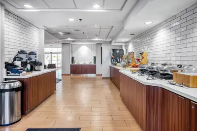 a lobby with a cafeteria with a counter with food at Fairfield Inn & Suites Rancho Cordova in Rancho Cordova