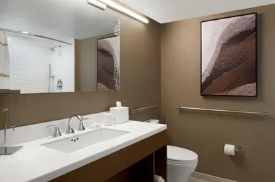 a bathroom with a sink and a toilet and a mirror at Sacramento Marriott Rancho Cordova in Rancho Cordova