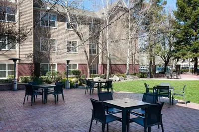 a patio with tables and chairs in front of a building at Residence Inn by Marriott Stockton in Stockton