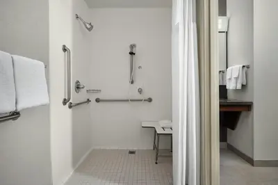 a white bathroom with a shower and a sink at Courtyard by Marriott Stockton in Stockton