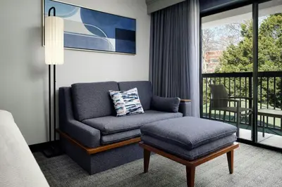 a living room with a couch and a ottoman at Courtyard by Marriott Stockton in Stockton