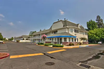 a large house sitting on the side of a street at Motel 6-Sacramento, CA - South Sacramento and Elk Grove in Sacramento