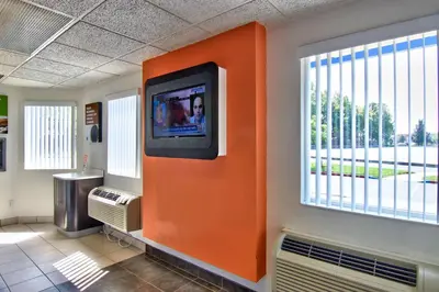 an orange wall with a tv on a wall at Motel 6-Sacramento, CA - South Sacramento and Elk Grove in Sacramento