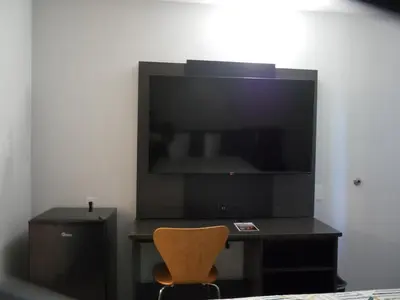 a living room with a tv and a chair at Motel 6-Sacramento, CA - South Sacramento and Elk Grove in Sacramento