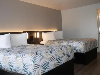 a hotel room with two beds with white pillows at Motel 6-Sacramento, CA - South Sacramento and Elk Grove in Sacramento