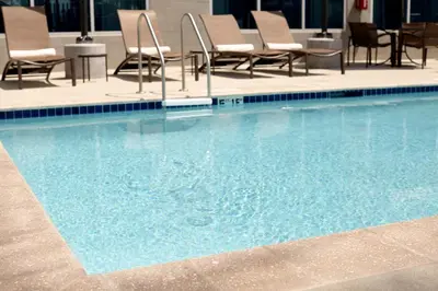 a large swimming pool with chairs and tables in a hotel at Hyatt Place Delano in Delano