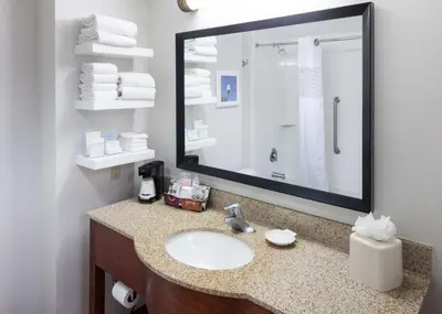 a bathroom with a sink and a large mirror at Hampton Inn & Suites Tulare in Tulare