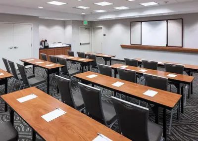 an empty classroom with wooden tables and chairs at Hampton Inn & Suites Tulare in Tulare