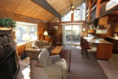 a living room with couches and a kitchen at 6B Meadow View in Wawona