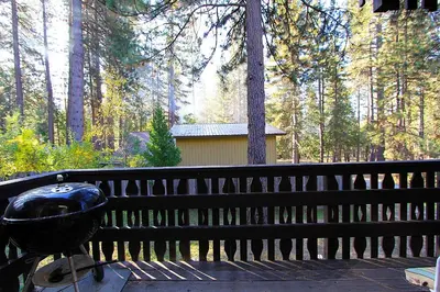 a grill sitting on a deck in the woods at 6B Meadow View in Wawona
