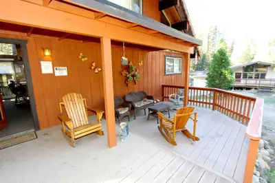 a porch of a house with two chairs and a dog at 6B Meadow View in Wawona