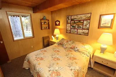 a bedroom with a bed and two tables and a window at 6B Meadow View in Wawona
