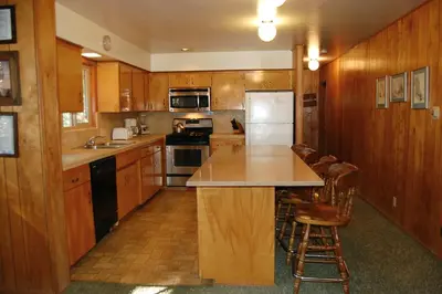 a kitchen with wooden cabinets and a counter top at 99 Yosemite Mountain Lodge in Wawona