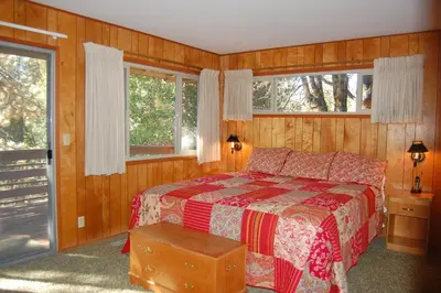 a bedroom with a bed and two windows at 99 Yosemite Mountain Lodge in Wawona