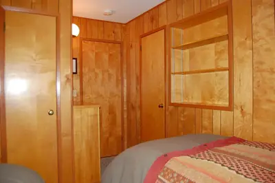 a bedroom with a bed and a wooden door at 99 Yosemite Mountain Lodge in Wawona