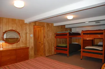 a bedroom with three bunk beds and a mirror at 99 Yosemite Mountain Lodge in Wawona
