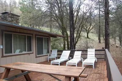 a group of white chairs sitting on a deck at 99 Yosemite Mountain Lodge in Wawona