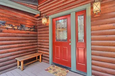 a red door and a bench on a porch at 1L The Tree House in North Wawona