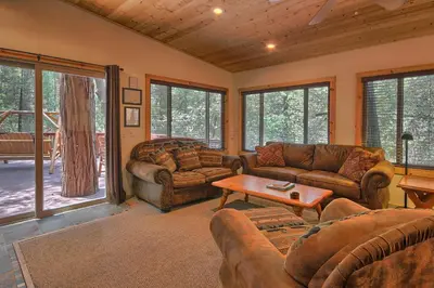 a living room with couches and a table at 1L The Tree House in North Wawona