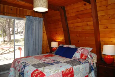 a bedroom with a bed in a log cabin at 46R Manzanita Lodge in Wawona
