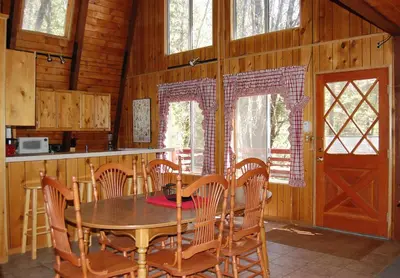 a dining room with a wooden table and chairs at 46R Manzanita Lodge in Wawona