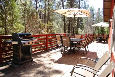a deck with a grill and a table and chairs at 46R Manzanita Lodge in Wawona